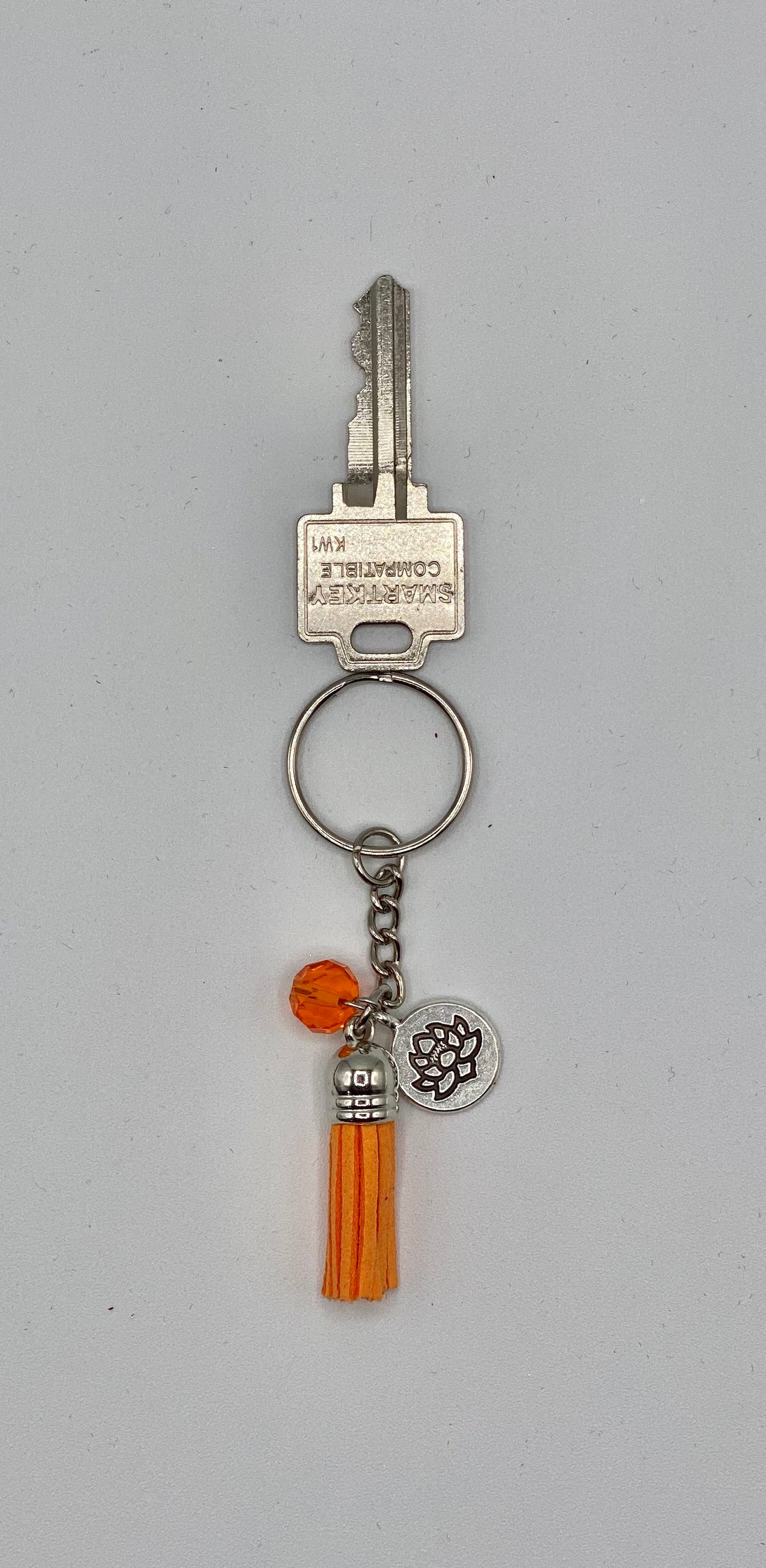 Key holder with orange tassels and lotus flower charm and orange bead