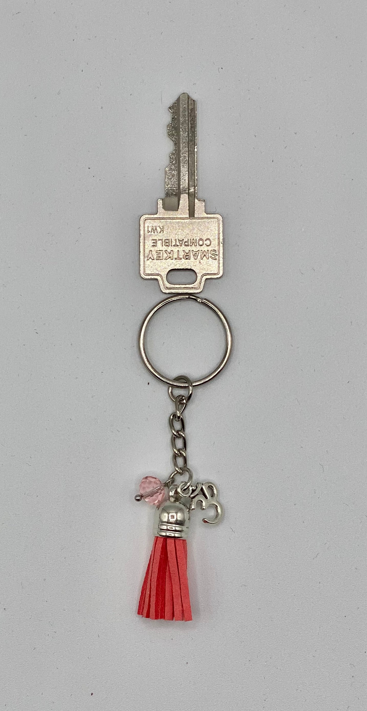 Key holder with light pink tassels and OM charm and pink glass bead