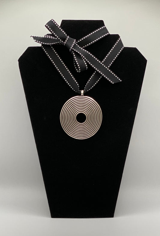 Black and white ribbon with silver plated spiral medallion